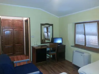a room with a desk with a computer and a mirror at Arkade turizem in Črniče