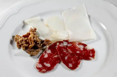 a white plate topped with cheese and jam and nuts at Arkade turizem in Črniče
