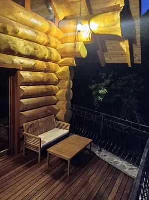 a wooden deck with a bench and a table at Brunarica Biopark -Log house Biopark in Grosuplje