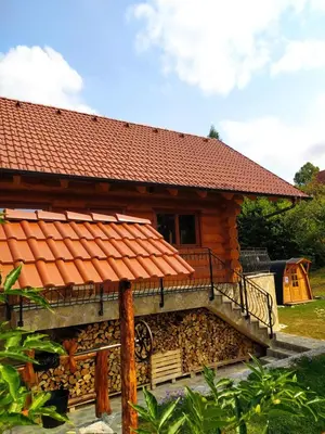 a log cabin with a porch and a balcony at Brunarica Biopark -Log house Biopark in Grosuplje