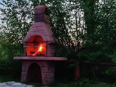 a brick oven with a fire inside of it at Brunarica Biopark -Log house Biopark in Grosuplje