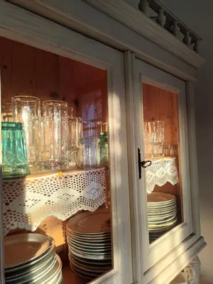 a cabinet filled with plates and glass dishes at A lovely house in Vipava valley in Vipava