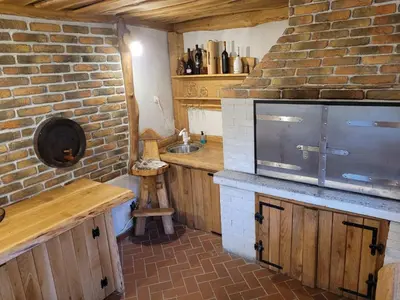 a kitchen with a sink and a brick wall at Holiday house Aronija in Šmarje pri Jelšah