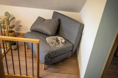 a gray chair with a furry pillow on it at Holiday house Aronija in Šmarje pri Jelšah