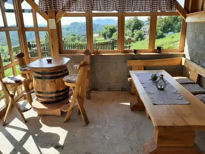 a room with a wooden table and a barrel at Holiday house Aronija in Šmarje pri Jelšah
