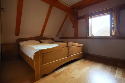 a bedroom with a bed in a room with a window at Zadnjica Holiday House in Soča