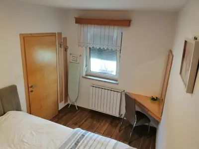 a bedroom with a desk and a bed and a window at Deno in Podgrad