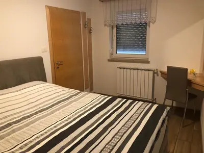 a bedroom with a bed and a desk and a window at Deno in Podgrad