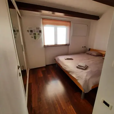 a small bedroom with a bed and a window at Apartma Rok in Plavje
