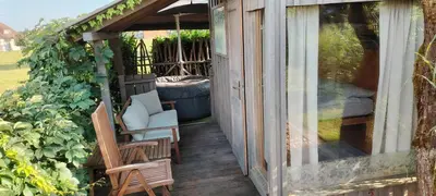 a porch with two chairs and a glass door at Glamping with a view in Smlednik