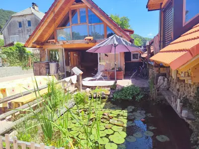 a house with a koi pond in front of a house at Apartma Caprivi Zavod za razvoj turizma Kočevski rog in Kočevje