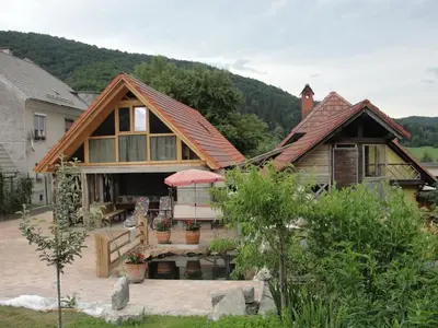 a house with a roof that has a patio at Apartma Caprivi Zavod za razvoj turizma Kočevski rog in Kočevje