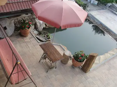 an umbrella and a bench next to a pool at Apartma Caprivi Zavod za razvoj turizma Kočevski rog in Kočevje
