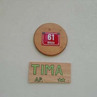 a clock on a wall with a sign on it at Apartma Tima in Bovec