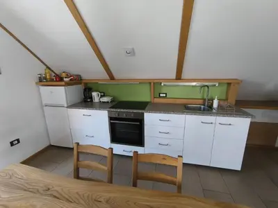 a small kitchen with white cabinets and a sink at Apartma Tima in Bovec