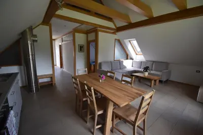 a kitchen and living room with a wooden table and chairs at Apartma Tima in Bovec