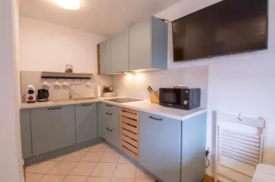 a small kitchen with white cabinets and a microwave at Apartment above Lake Bled in Bled