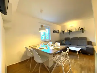 a living room with a table and a couch at Apartment above Lake Bled in Bled