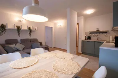 a kitchen and a living room with a table and chairs at Apartment above Lake Bled in Bled