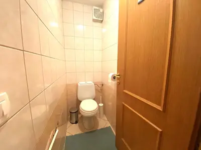 a small bathroom with a toilet and a door at Apartment above Lake Bled in Bled