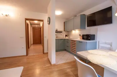 a kitchen with blue cabinets and a table and chairs at Apartment above Lake Bled in Bled