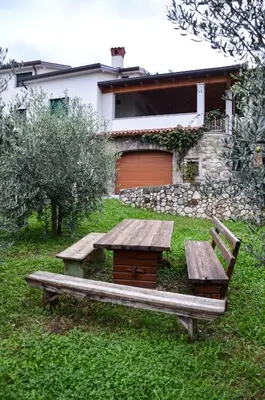 a wooden picnic table and bench in a yard at Apartmaji Tanto Malovše in Črniče