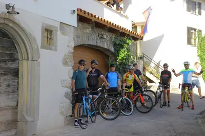 a group of people standing next to a building with their bikes at Apartmaji Tanto Malovše in Črniče