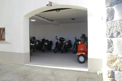 a garage with a bunch of motorcycles parked in it at Apartmaji Tanto Malovše in Črniče