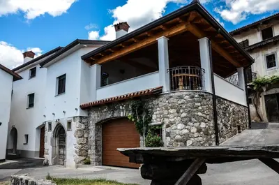 a house with a balcony and a garage at Apartmaji Tanto Malovše in Črniče