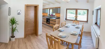 a dining room and kitchen with a table and chairs at House Hiperbola & Outdoor Activities in Bovec