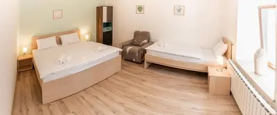 a room with two beds and a chair in it at House Hiperbola & Outdoor Activities in Bovec