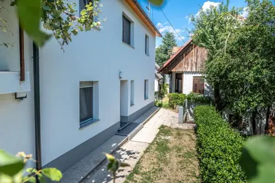 an alley between two white buildings with trees at House Hiperbola & Outdoor Activities in Bovec