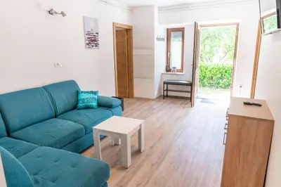 a living room with a blue couch and a table at House Hiperbola & Outdoor Activities in Bovec