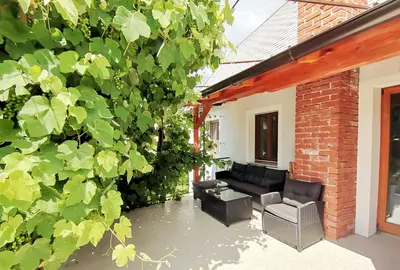 a patio with a couch and a chair and a brick building at Pri Zajcu in Bovec