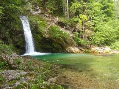 a waterfall in the middle of a river at APARTMENT WITH A VIEW in Bohinjska Bistrica