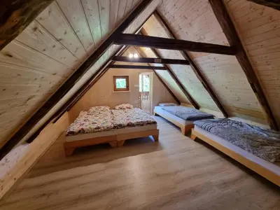 a bedroom with two beds in a attic at Počitniška hišica Žagar in Podčetrtek