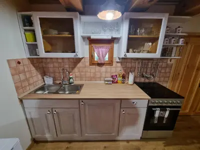 a small kitchen with a sink and a stove at Počitniška hišica Žagar in Podčetrtek
