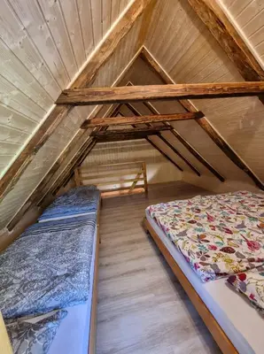 two beds in the attic of a house at Počitniška hišica Žagar in Podčetrtek