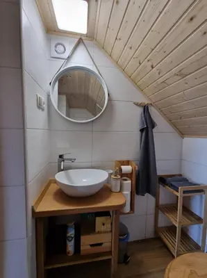 a bathroom with a sink and a mirror at Počitniška hišica Žagar in Podčetrtek