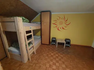 a room with bunk beds with a sun on the wall at The RiverSide Chill Hostel in Bled