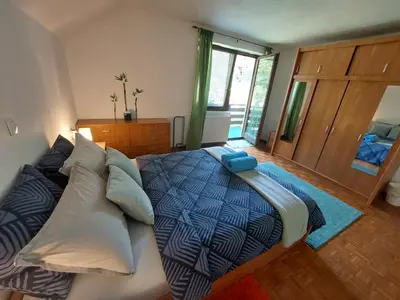 a bedroom with a bed with a blue comforter and pillows at The RiverSide Chill Hostel in Bled