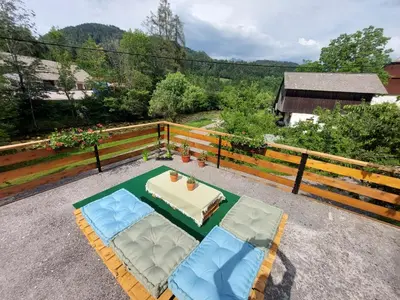 a patio with a table and two chairs and a table at The RiverSide Chill Hostel in Bled