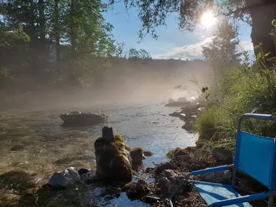 a river with fog on the side of it at The RiverSide Chill Hostel in Bled