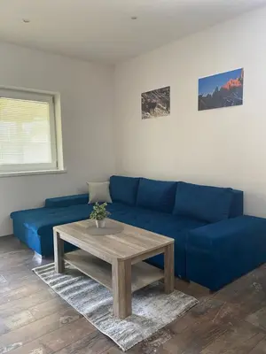 a living room with a blue couch and a table at Apartma Stres in Bovec