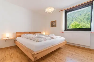 a bedroom with a bed and a large window at Kranjska gora balcony apartment in Kranjska Gora