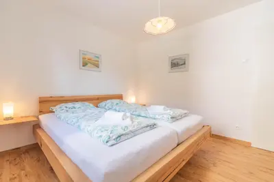 a bedroom with a bed with blue and white sheets at Kranjska gora balcony apartment in Kranjska Gora