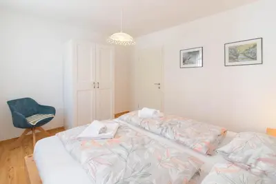 a bedroom with a bed and a blue chair at Kranjska gora balcony apartment in Kranjska Gora