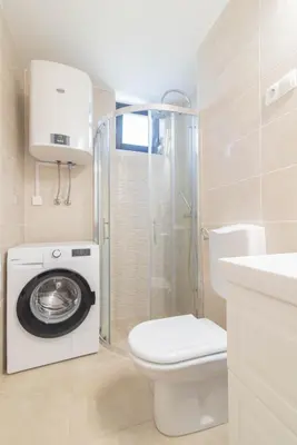a bathroom with a toilet and a washing machine at Kranjska gora balcony apartment in Kranjska Gora