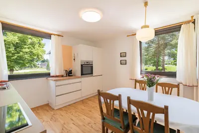 a kitchen and dining room with a table and chairs at Kranjska gora balcony apartment in Kranjska Gora