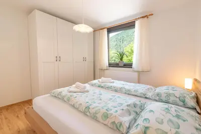 a bedroom with a large bed with a window at Kranjska gora balcony apartment in Kranjska Gora